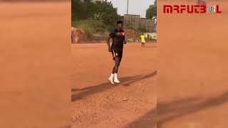 Onana playing soccer in an open field in Cameroon
